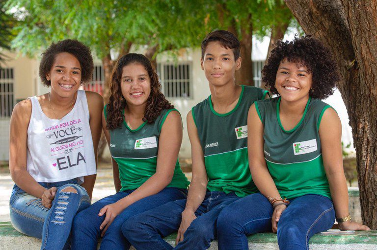 Estudantes em atividade escolar representando ações de convivência e enfrentamento da violência de gênero nas escola
